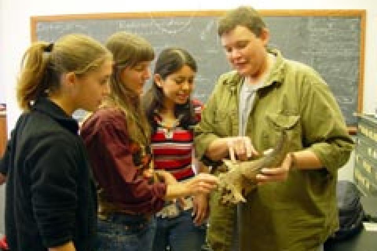 Student showing other students an artifact