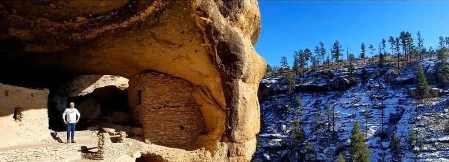 Carlton standing in a cliff dwelling