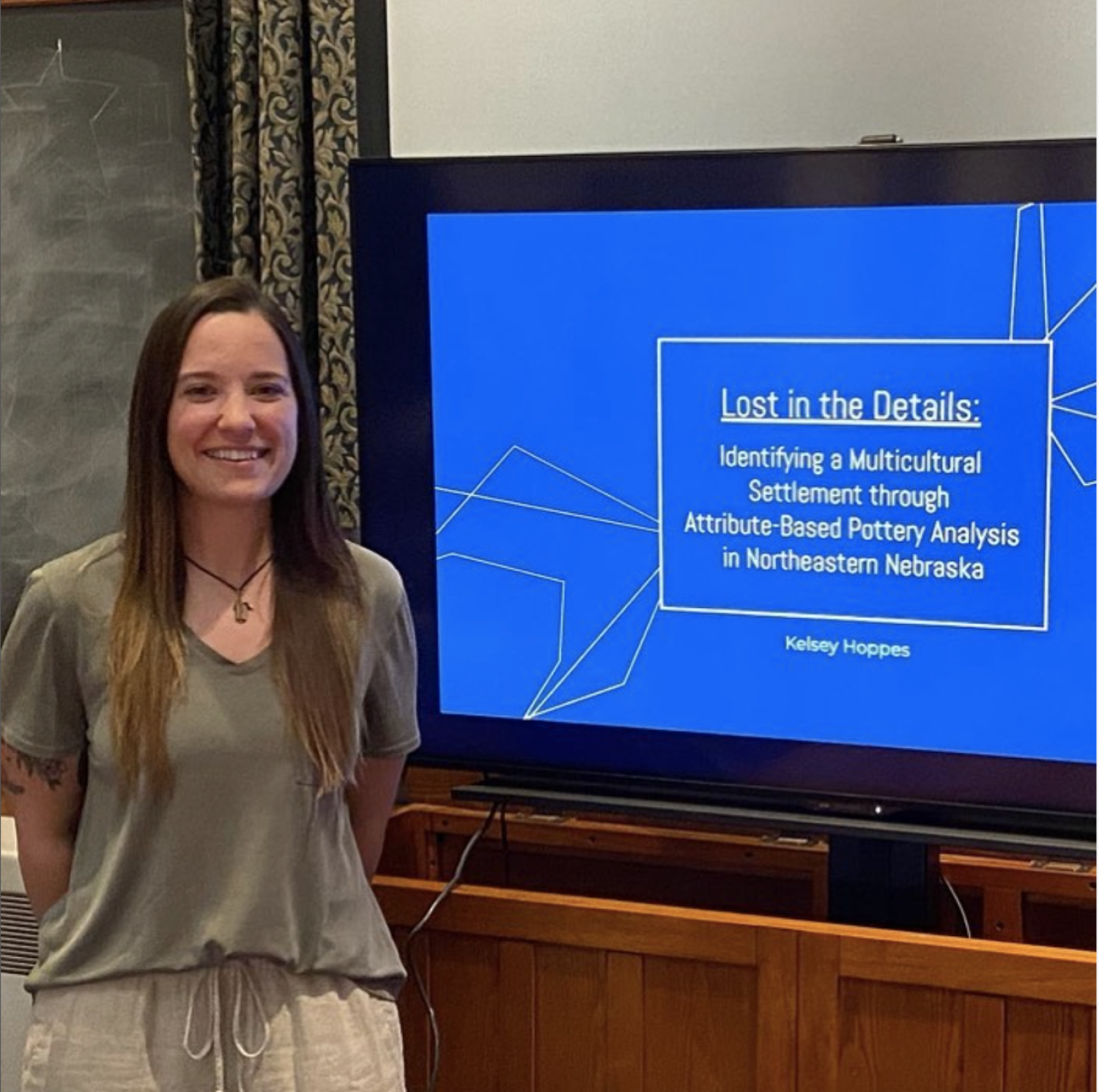 Kelsey in front of her paper defense slide show