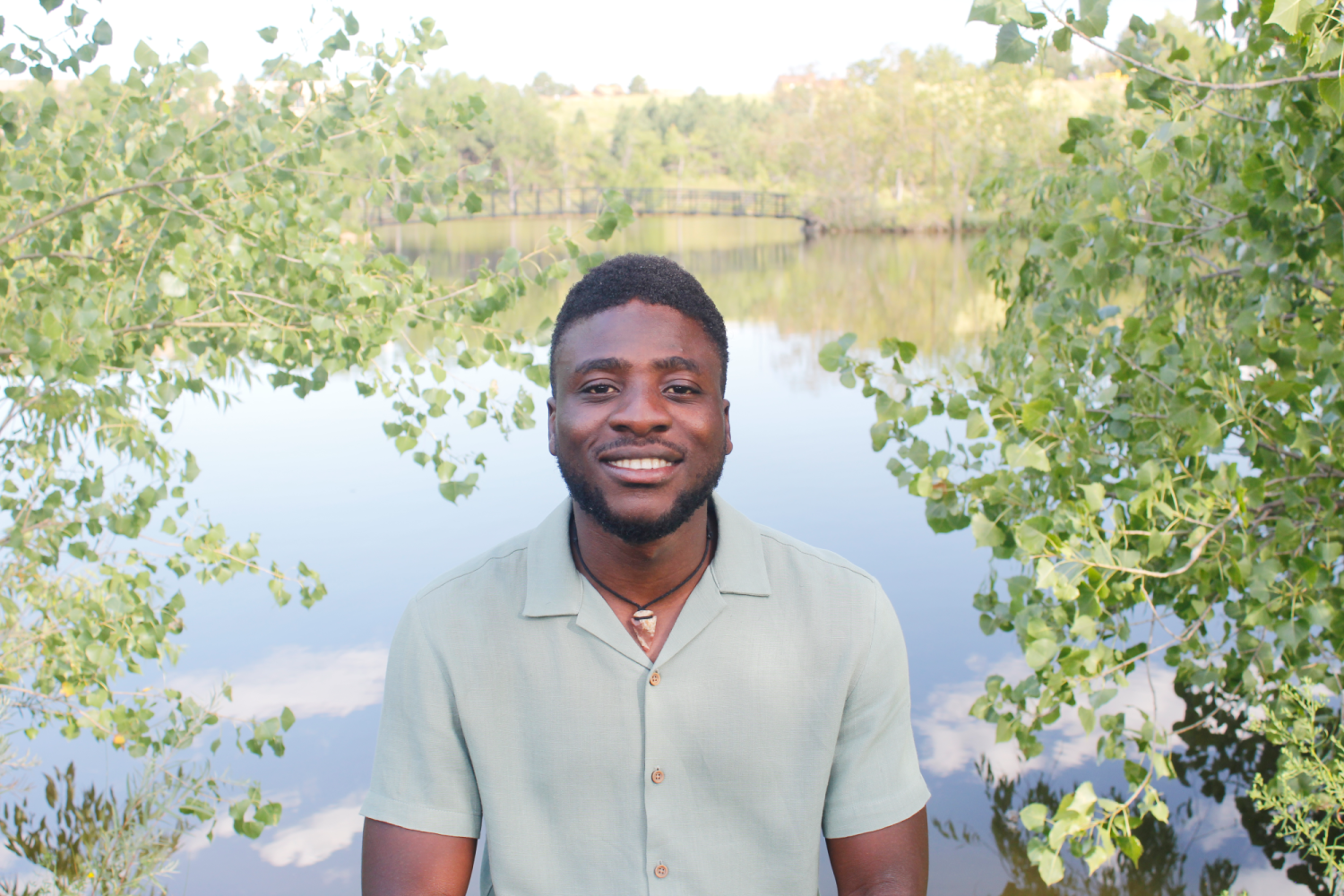 Olumide in front of a pond