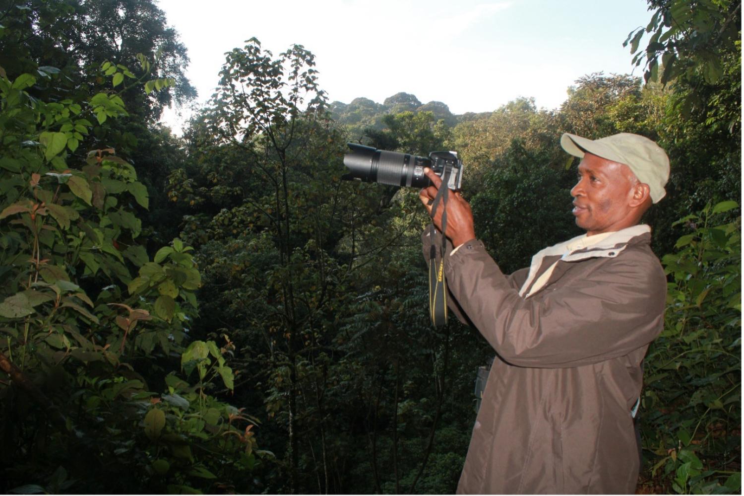 Shadrack holding a camera in the field