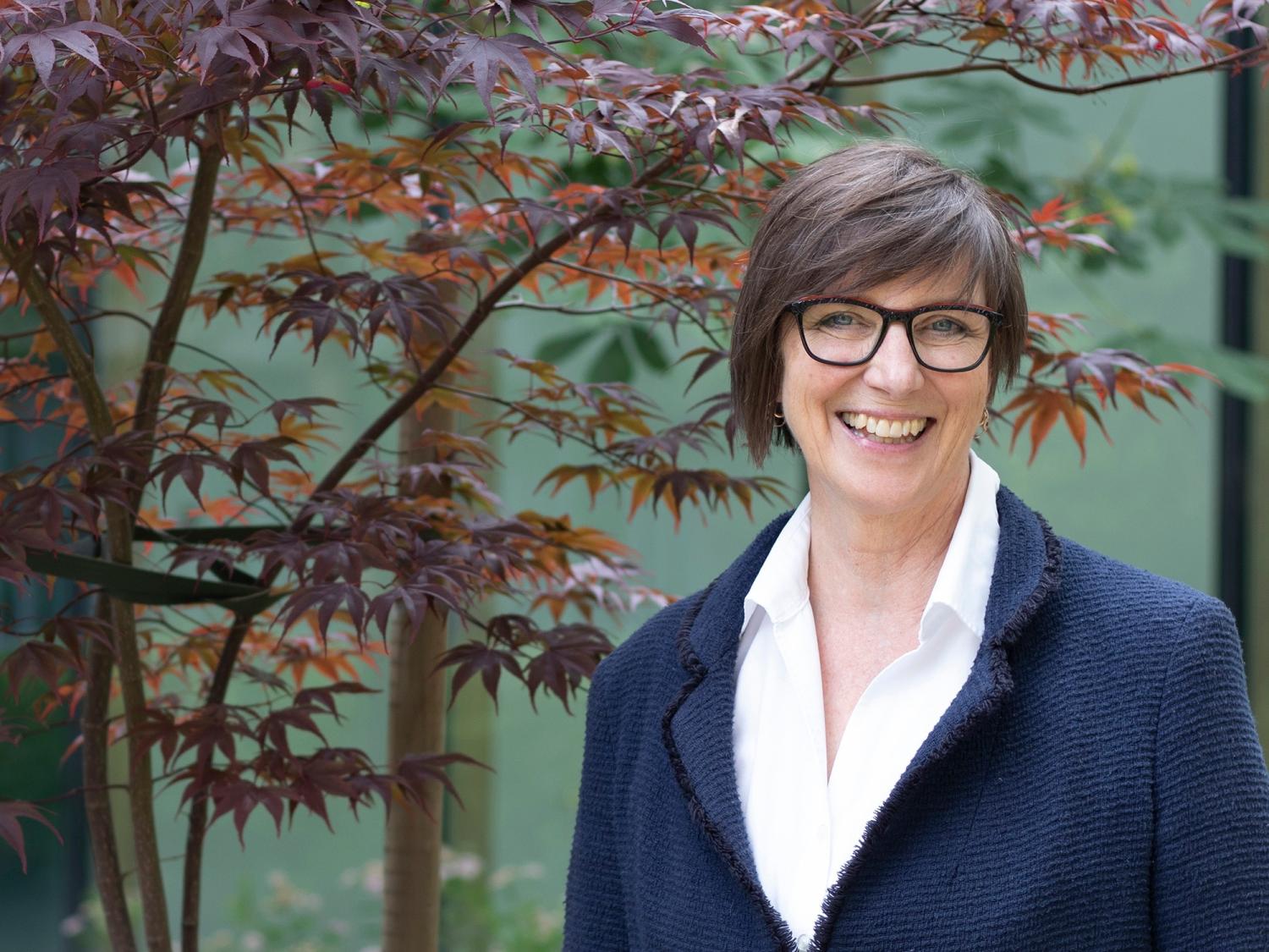 Susan Erikson next to a tree
