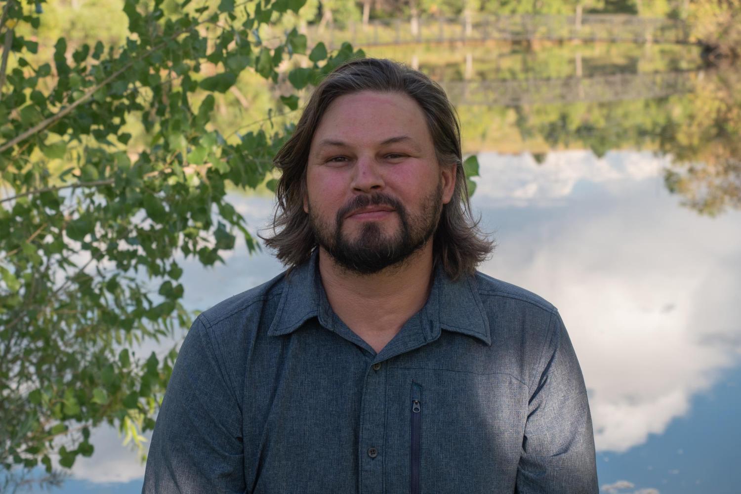 Tom Hanson sitting in front of a pond