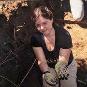 Dr. Hosek during the excavation and relocation of the Loretto Heights Cemetery in Denver (June 2022). She is holding one of the crosses affixed to the original coffins.