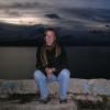 Carol Conzelman sitting on rocks in front of a lake