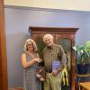 Carole and Warren shaking hands and holding books