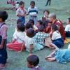 Dalai Lama sitting with Children