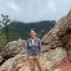 Kelsey on a hike standing in front of some rocks