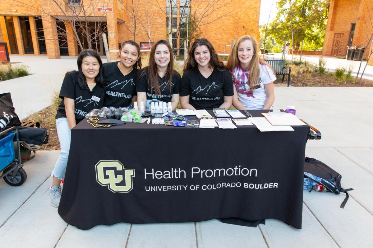 students behind a desk reading health promotion