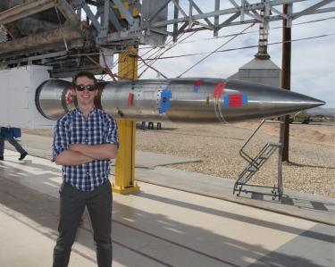 Nick Erickson in front of a rocket