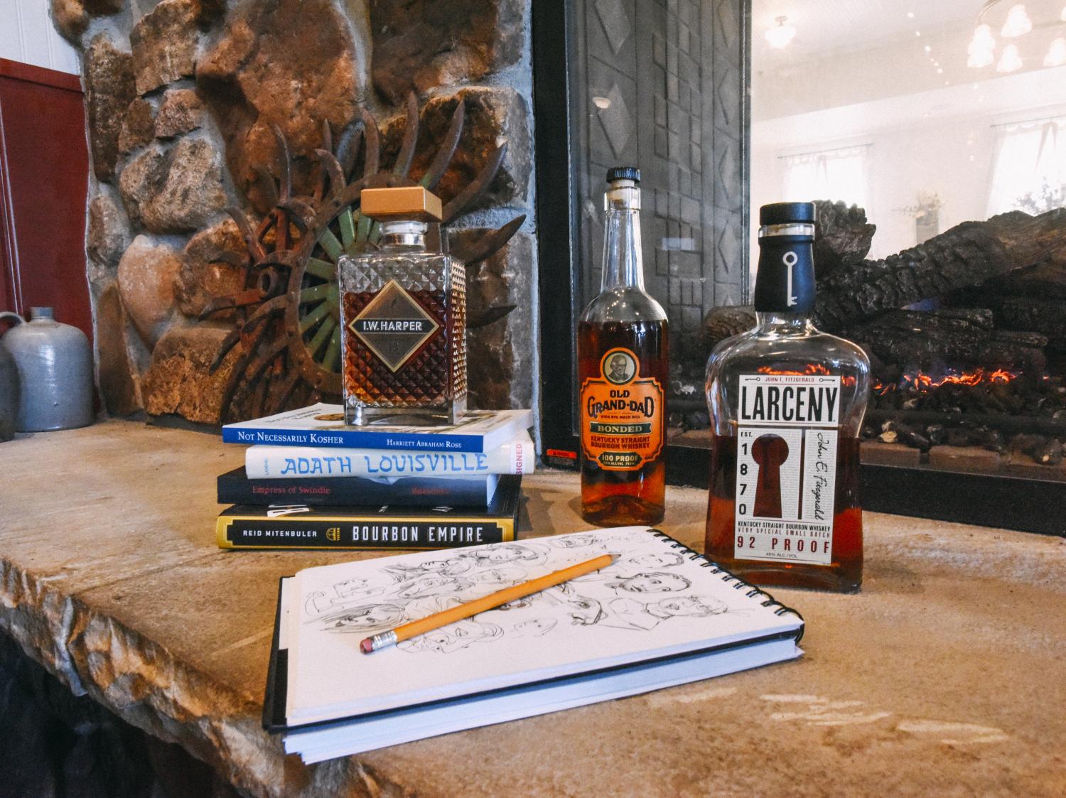 JT Waldman’s sketch book surrounded by bottles of bourbon