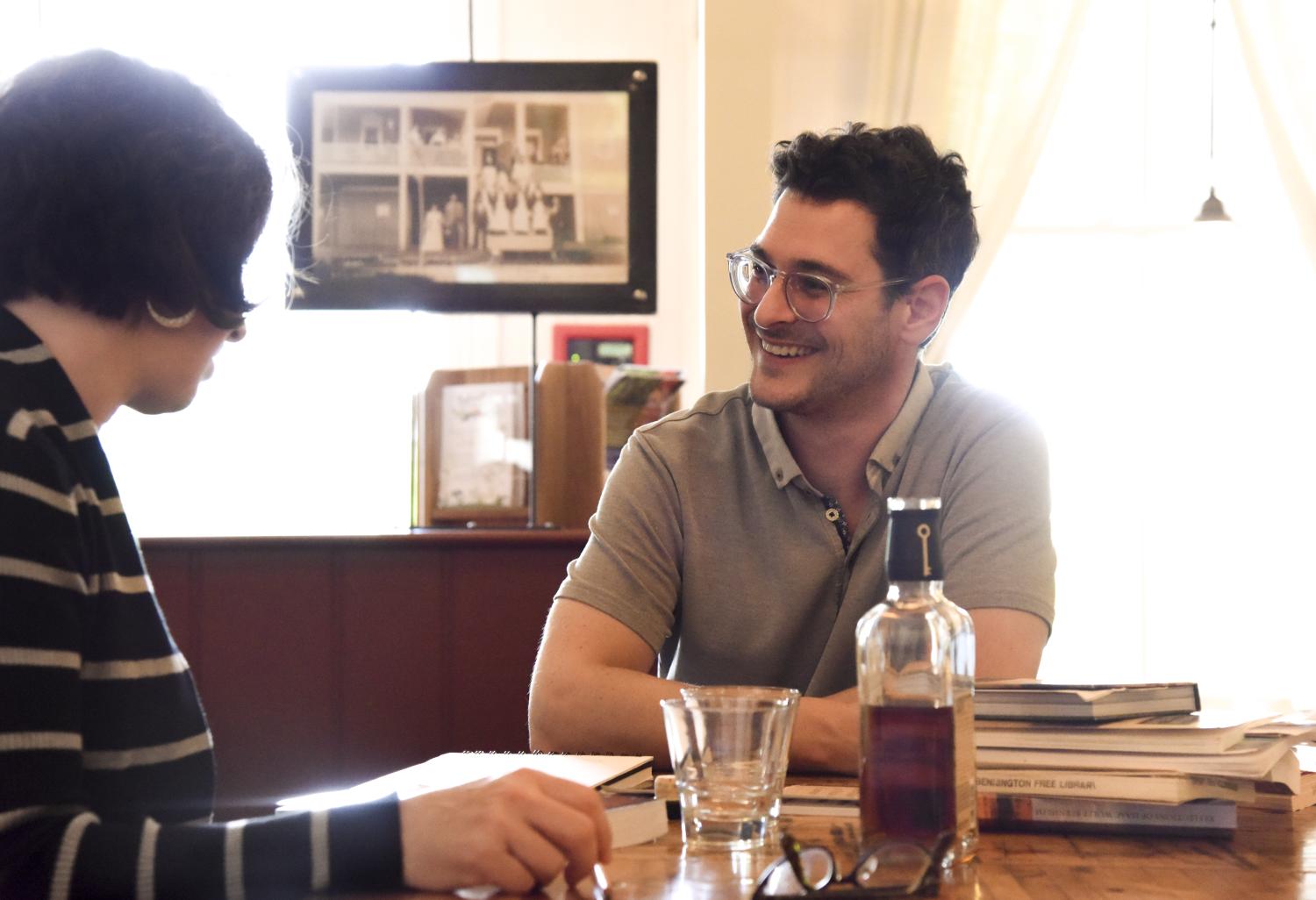 Janice Fernheimer and JT Waldman sitting at a table at work and smiling