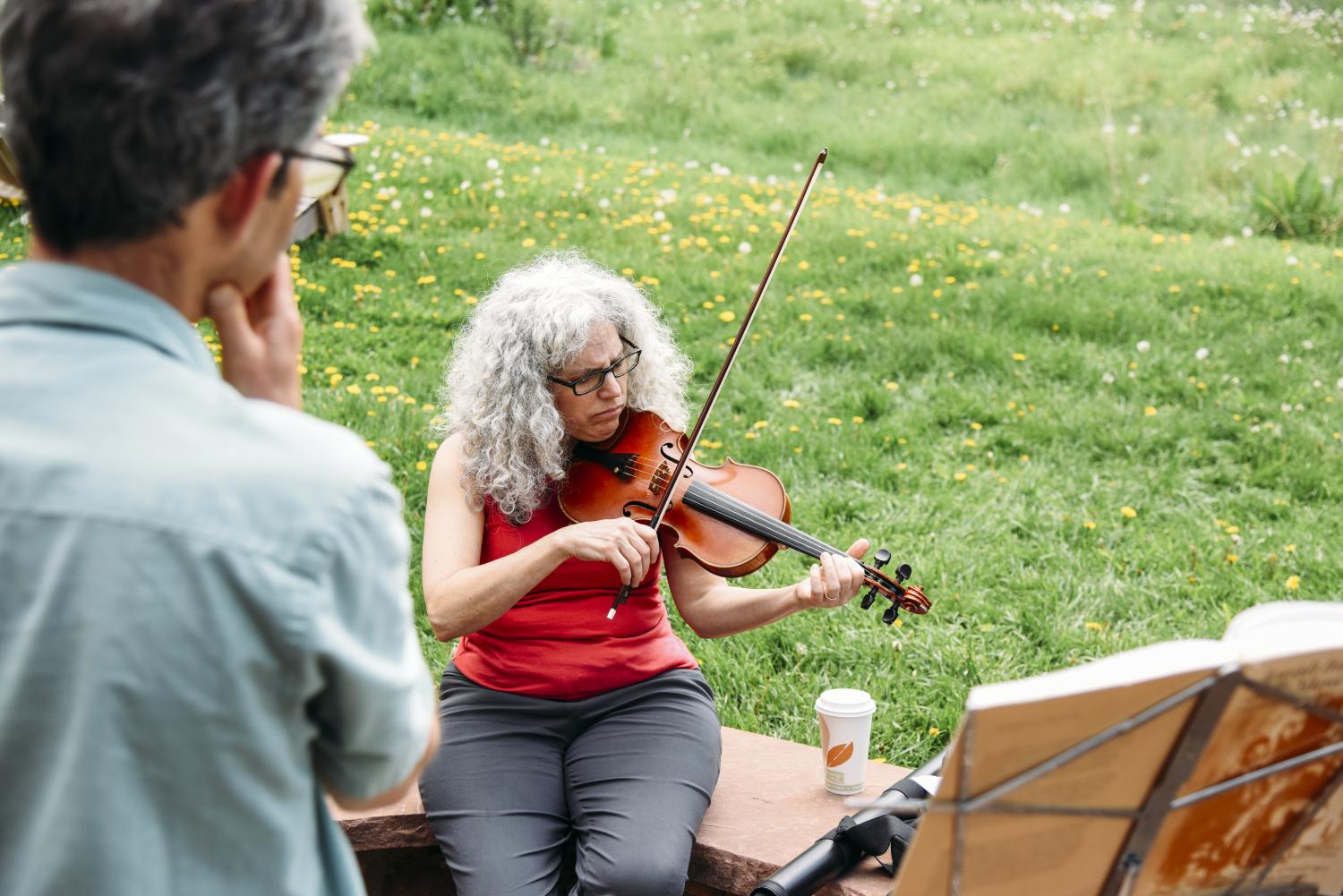 Alicia Svigals playing violin and Yonatan Malin watching her