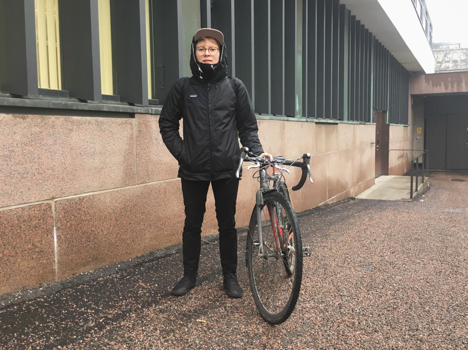 Emil Uuttu standing besides her bike