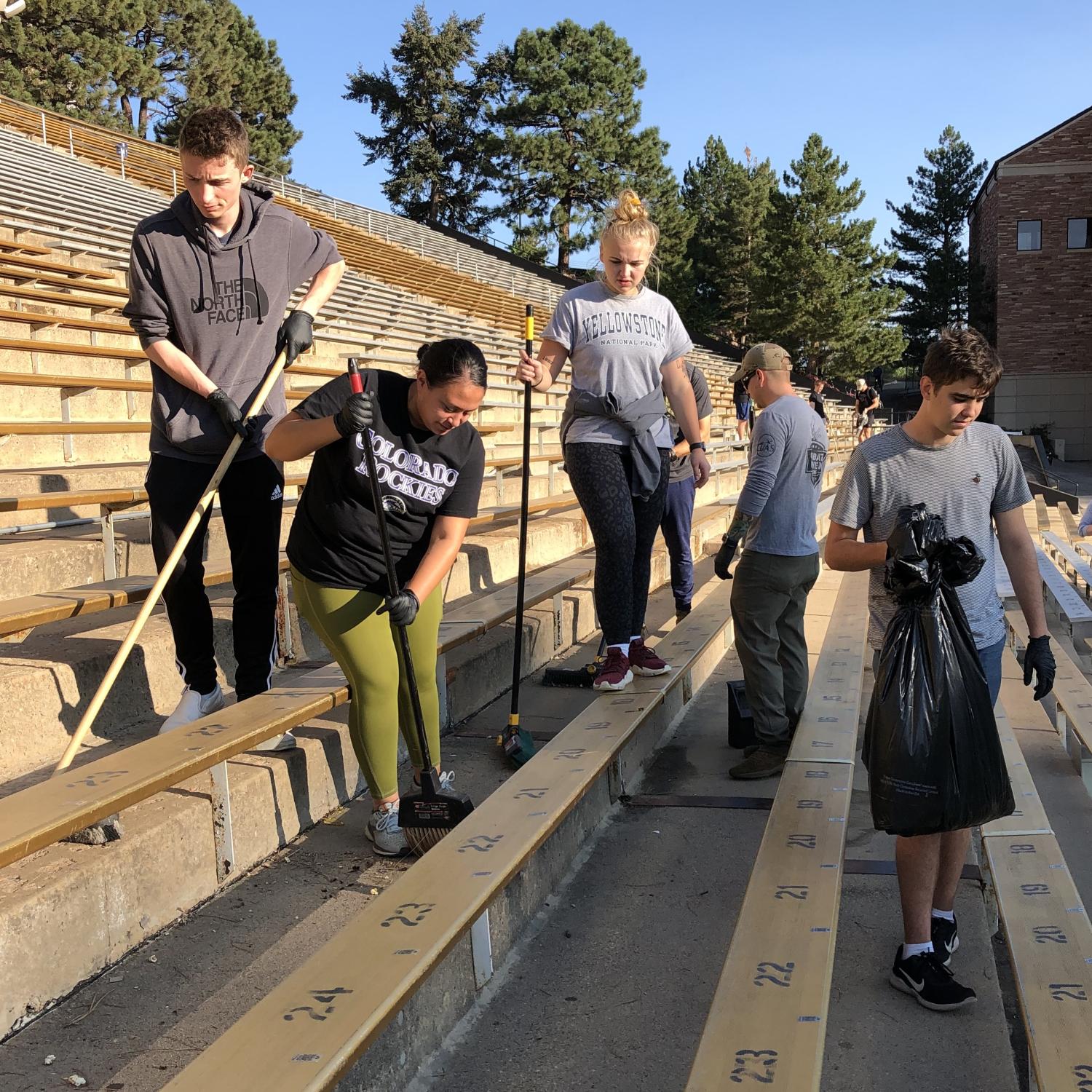 Army ROTC Cadets use brooms behind the leaf-blowers to make the final sweep of the stadium.