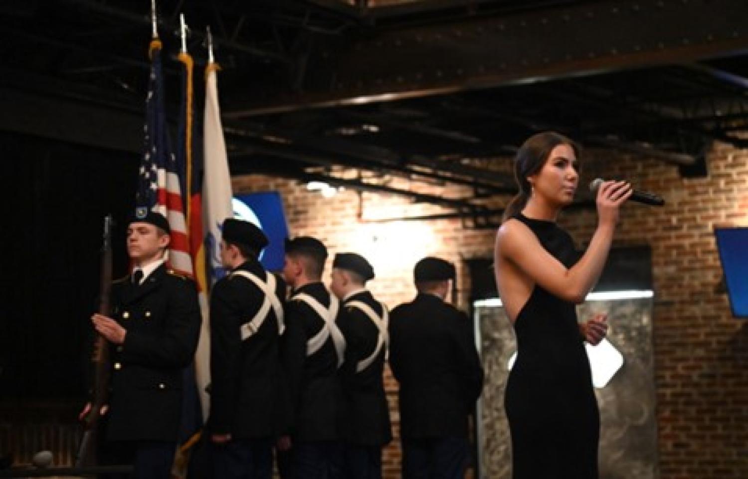 Cadet Lily Bauer sings the National Anthem during the posting of the Colors.