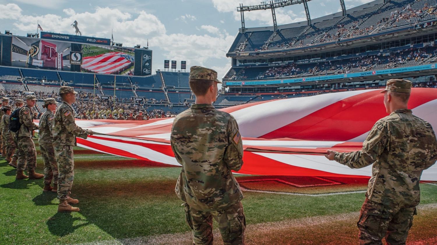 AROTC Cadets holding a large U.S. Flag on the field at Mile High for the 9/11 remembrance event. Photo courtesy of Cadet Decker.