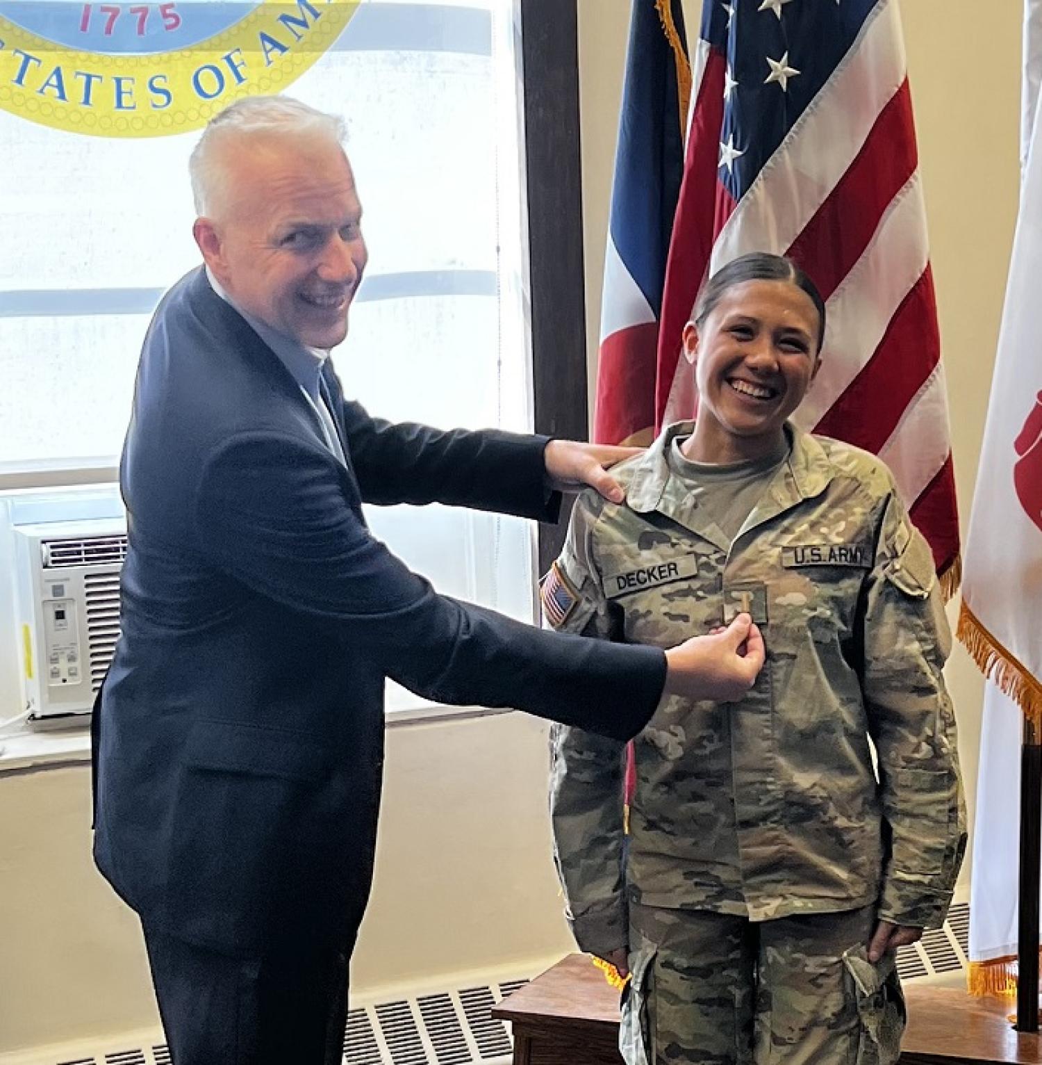 Second Lieutenant Arianna Decker having her new rank placed on her uniform by her father. Photo courtesy of CPT Chris Head.