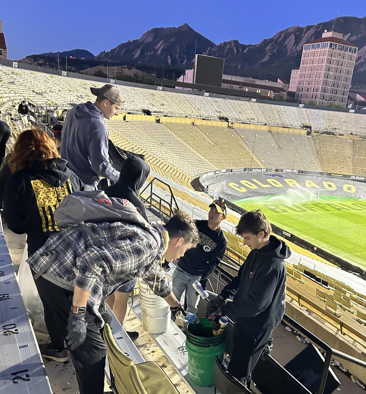 Army ROTC Cadet dumping out liquids into a bucket during the Stadium Clean-up on Sunday. Photo courtesy of the Golden Buffalo Battalion.