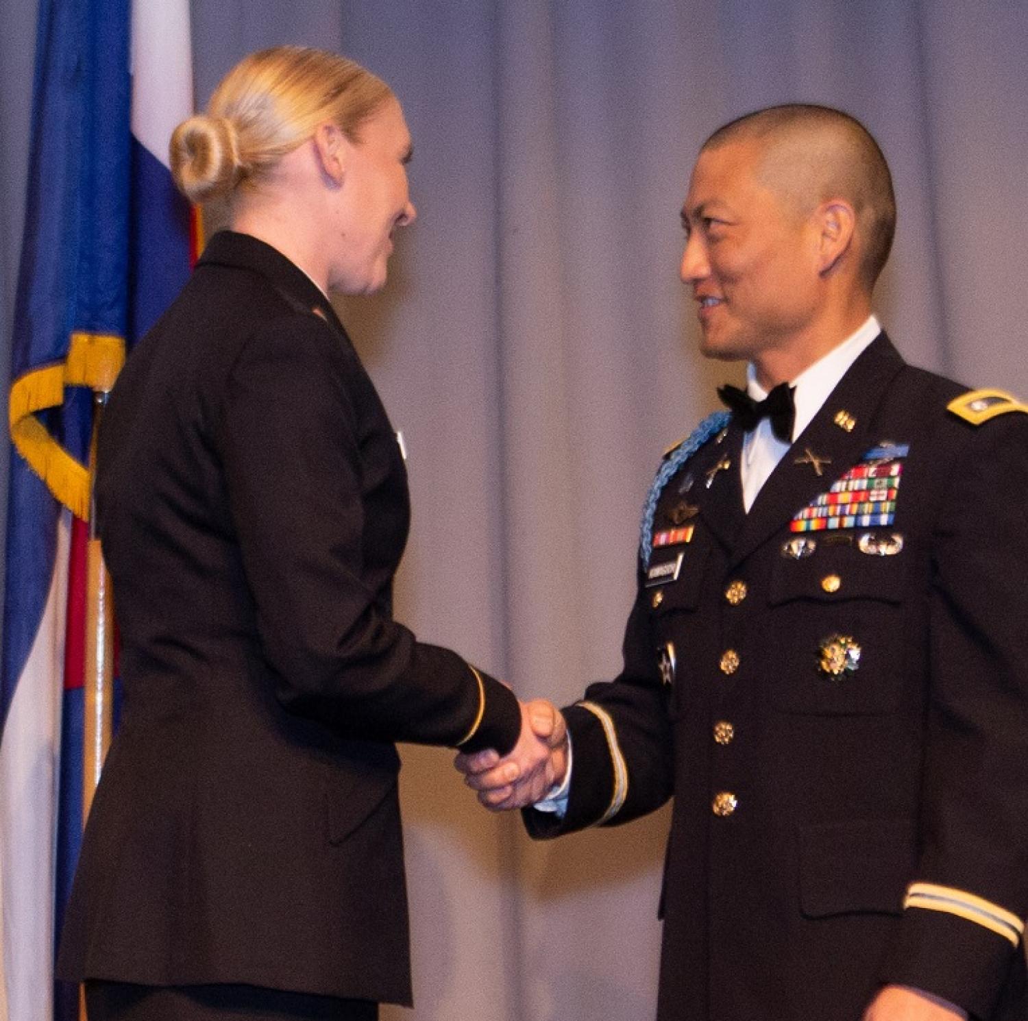 Cadet Stephanie Hunnel shakes hands with LTC Bryce Kawaguchi as she accepts her Armor pin. Photo courtesy of Tamara’s Camera, Erie, CO.