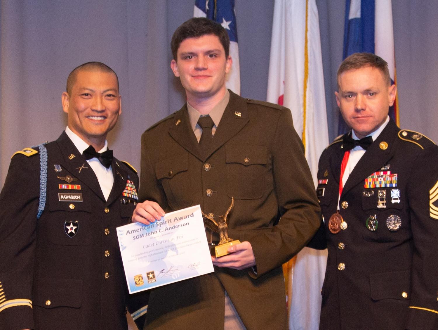 Cadet Christian Fin accepting the American Spirit Award (middle), presented by LTC Bryce Kawaguchi (left) and MSG Evan Reed (right). Photo courtesy of Tamara’s Camera, Erie, CO.