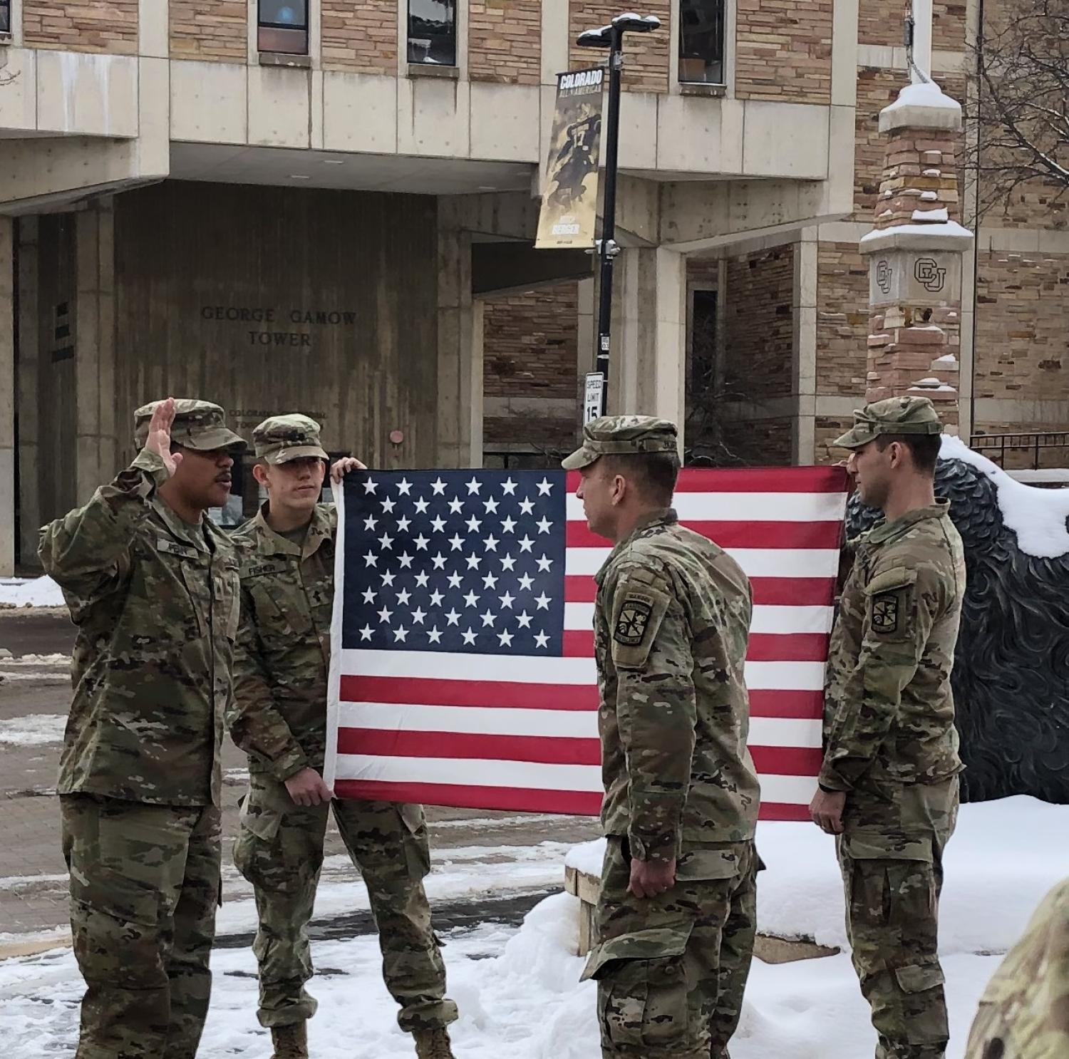 CDT Jack Fisher (L) and CDT Tyson Pyles (R), Two CU AROTC Cadets hold the U.S. Flag while MAJ Joshua James swears in SGT Russell Penn (hand raised on left).