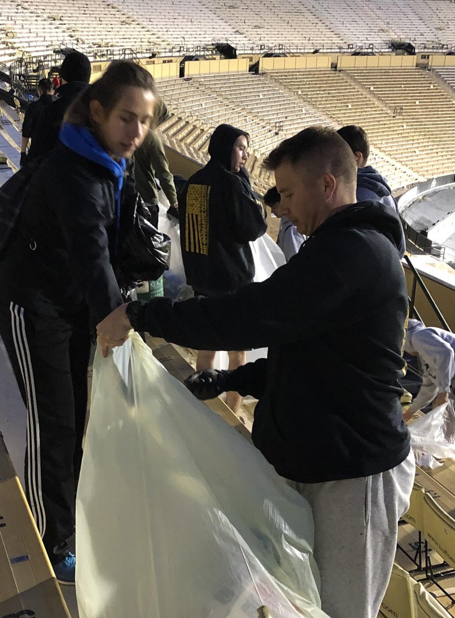 Army ROTC Cadet placing compostable items into the green bag. Photo courtesy of the Golden Buffalo Battalion.