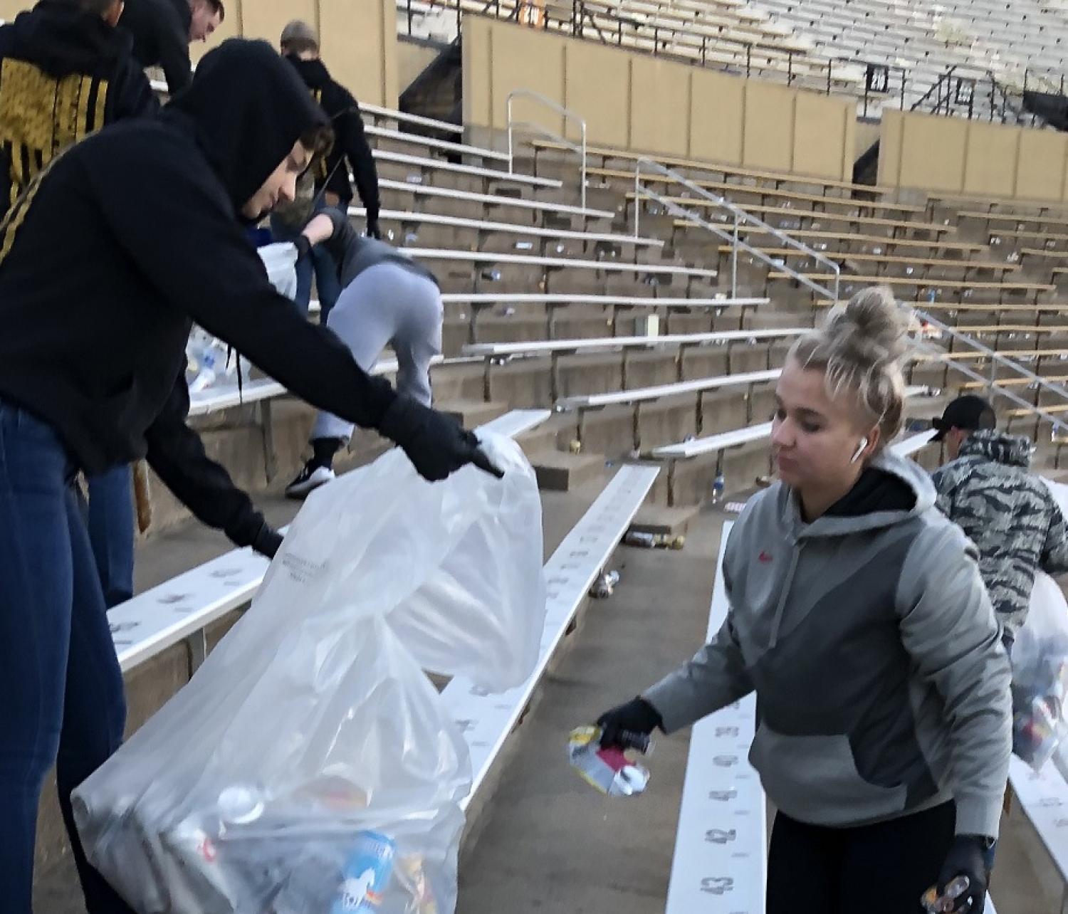 Army ROTC Cadet placing cans and bottles items into the clear bag. Photo courtesy of the Golden Buffalo Battalion.