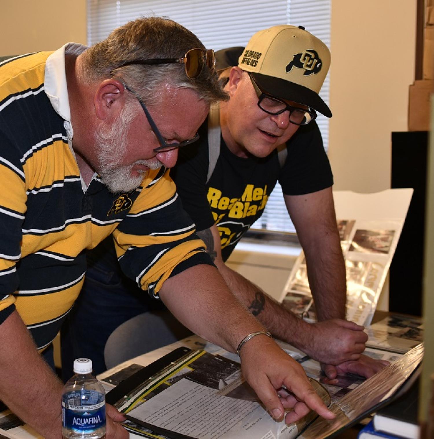 Army ROTC GBB alumni and veteran’s looking at old photos of when they attended school at CU-Boulder in the 1989-91 school years.