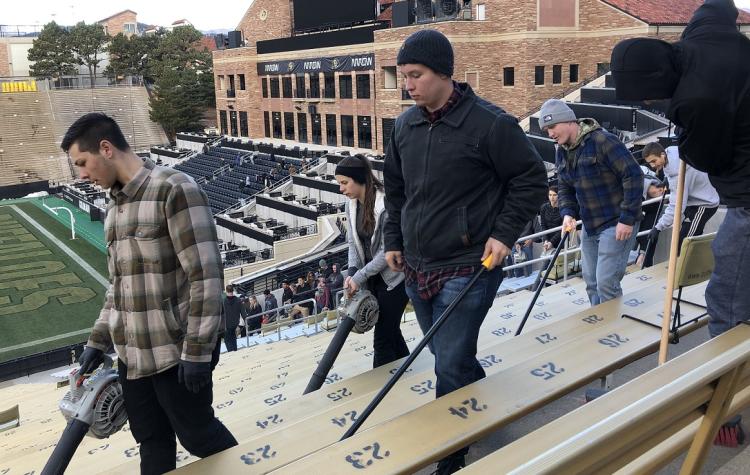 Army ROTC Cadets use leaf-blowers and brooms to make the final sweep of the stadium.