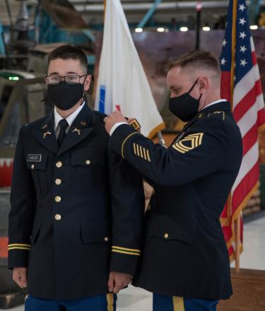 MSG Evan Reed [right] is pinning on Cadet William Ascik’s Second Lieutenant shoulder bars. Photo courtesy of Cadet Arianna Decker.