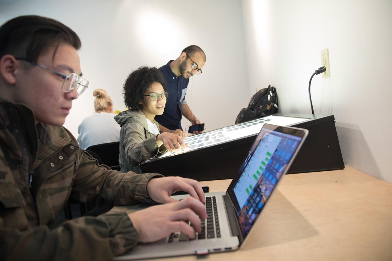 two students working on editing images in the digital lab