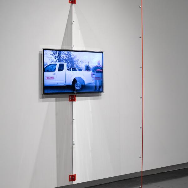 “Plexi Partition: 40 Inch Monitor, The University of Colorado Art Museum, Boulder CO,” 2021 Shaped Plexiglass, metal brackets, and hardware.