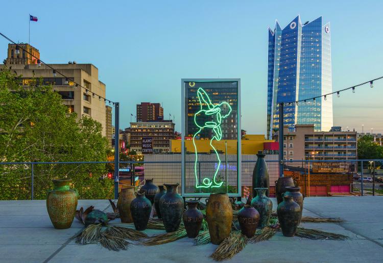 Sama Alshaibi, “The Cessation” (2019), neon, aluminum, acrylic, palm fronds, water, copper, terracotta, and sound (commissioned by Artpace San Antonio, photo courtesy Seale Photography Studios)