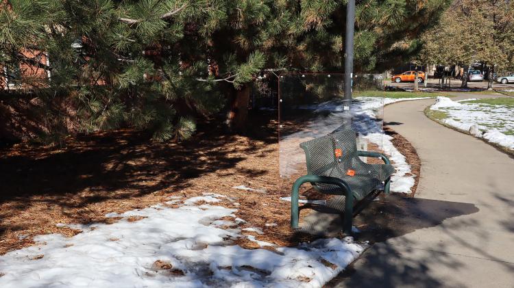 Plexi Partition: Green Bench at Greenleaf Park, Boulder CO, 2020 Shaped Plexiglass, metal brackets, and hardware. A Plexiglass partition designed and previously installed for a week on a bench in Greenleaf Park. It is now displayed separately from its intended environment, highlighting the marks of its time in public space.