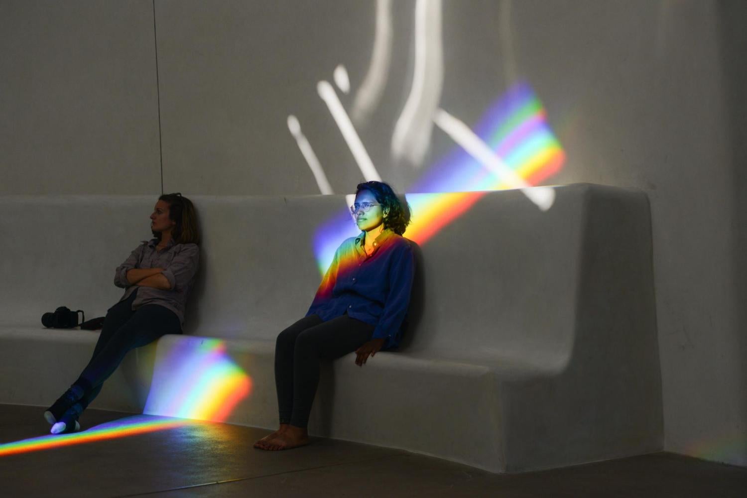 Students sitting with reflected rainbow on her face