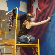 Ellie Marcotte painting a mural