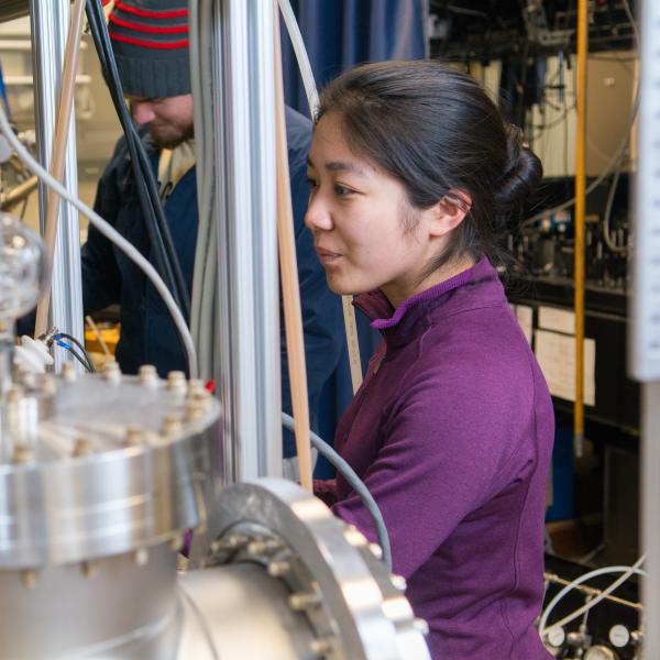 A student looks a complex physics lab equipment.
