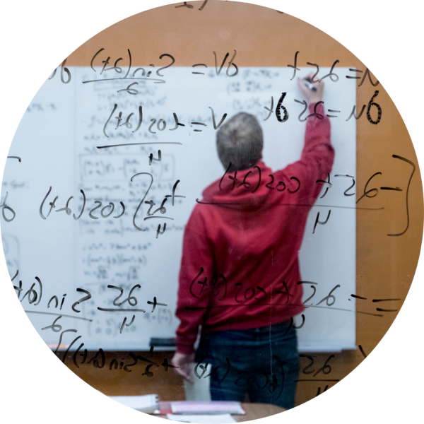 A student works out a complex math algorithm by writing the calculus formula on a window