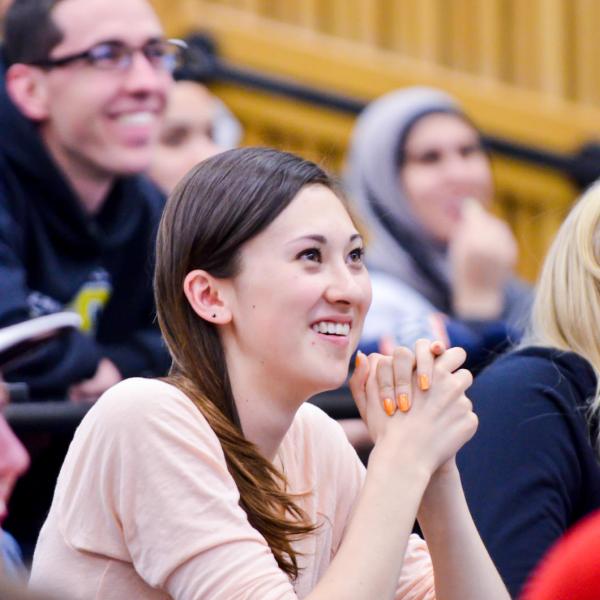 A girl sitting in a lecture class smiling