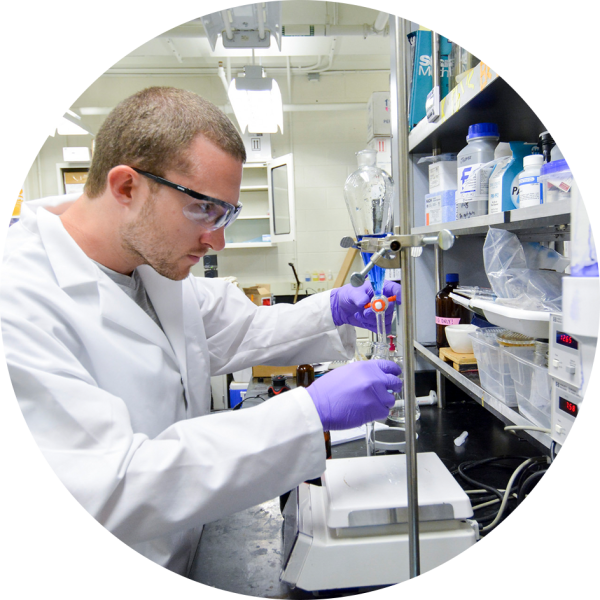 A lab technician adds an unknown chemical to a small sampling dish.