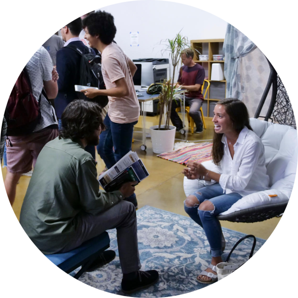 Students gather in a bustling room and chat/interview one another.