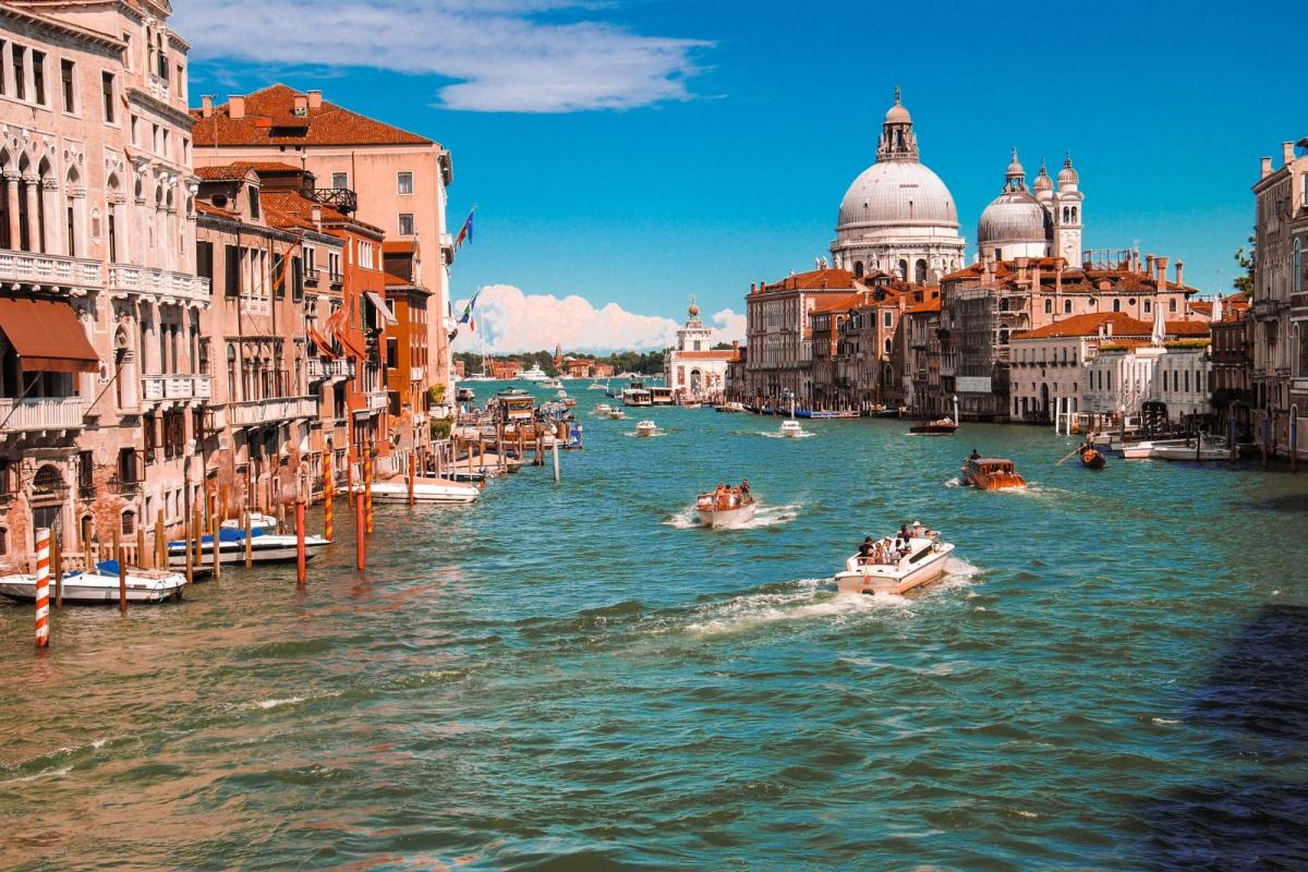 The iconic waterways of Venice are seen with people racing boats.