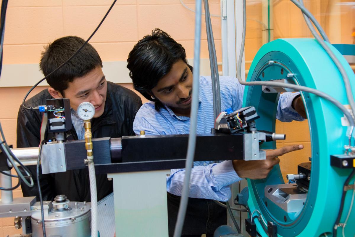 Photo of student and professor in a physics lab