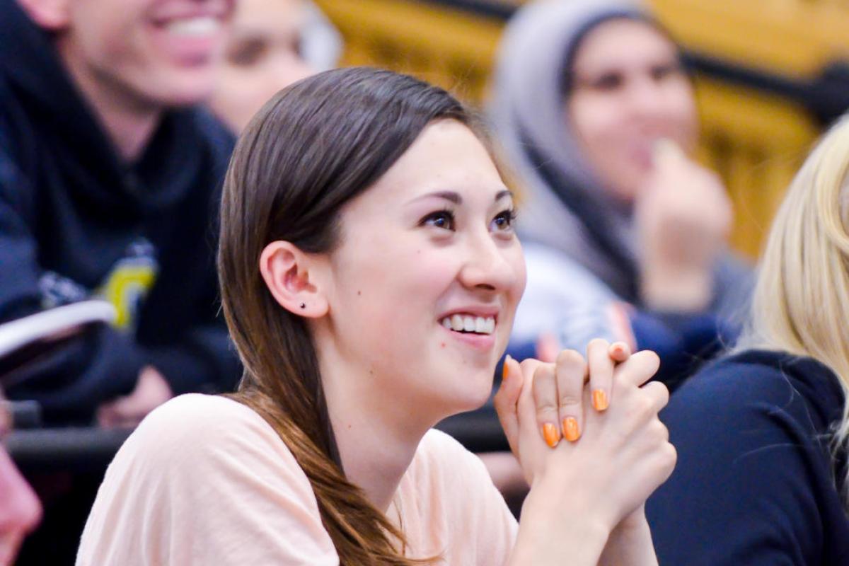A girl sitting in a lecture class smiling