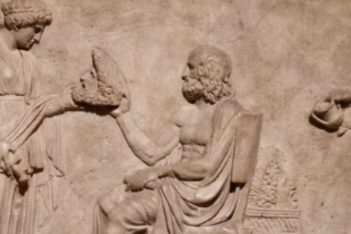 A marble bas-relief show Euripides (seated), a standing woman holding out a theater mask to him (left) and the god Dionysus (right), dated to between the 1st century BCE and the 1st century CE, from the Misthos collection in the Istanbul (Turkey) Archaeological Museum. (Photo: John-Grégoire/Wikimedia Commons)