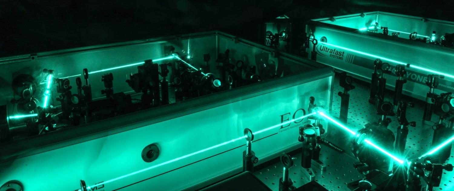A chemistry experiment shows lasers beaming around a maze of equipment.