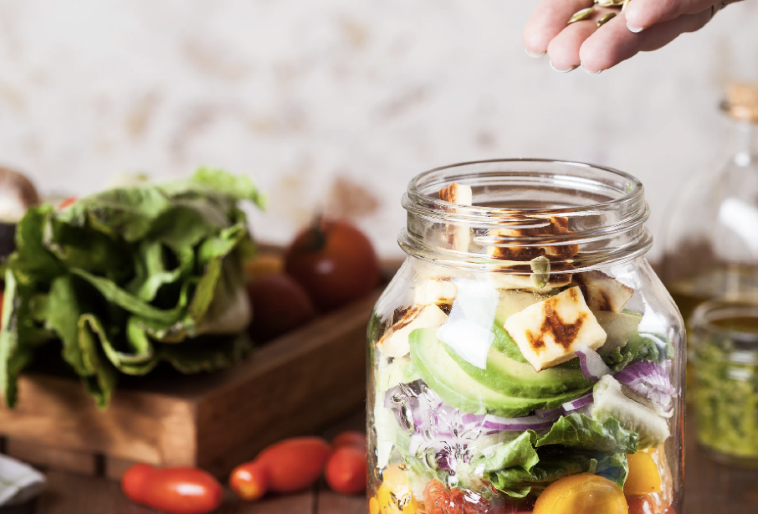 meal prepping: mason jar with health ingredients like pumpkin seeds, tomatoes, bell peppers and more.