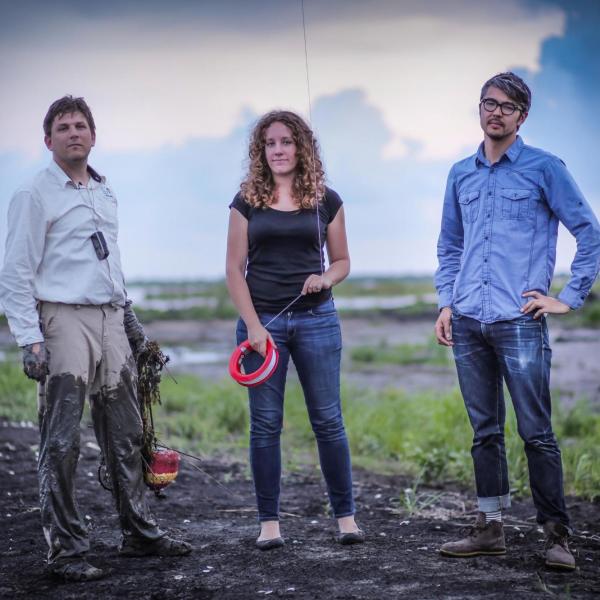 three faculty standing in a field for research