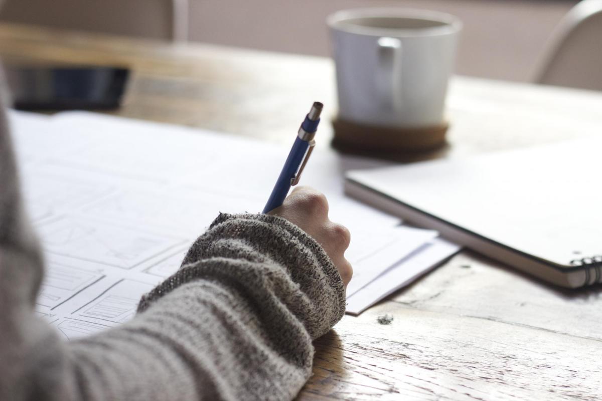 hand holding a pen and writing